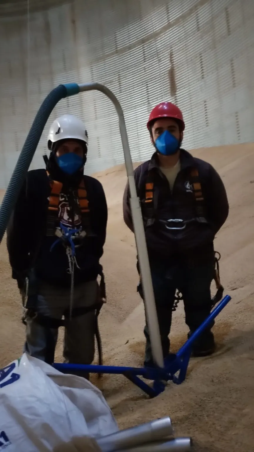 Colaboradores da Qualitas com equipamento de sondagem no silo.